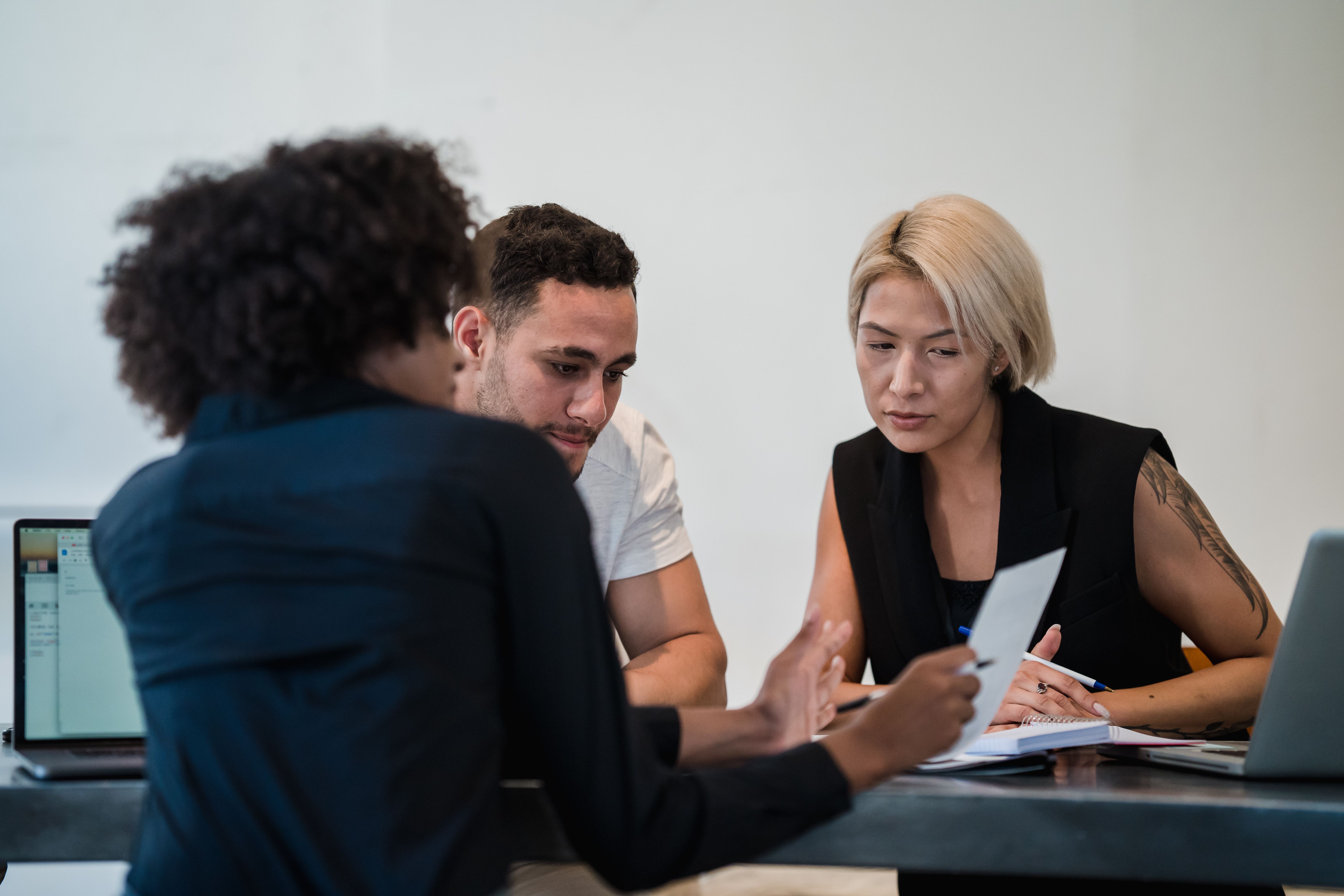 A team collaborating around a table with laptops and notes